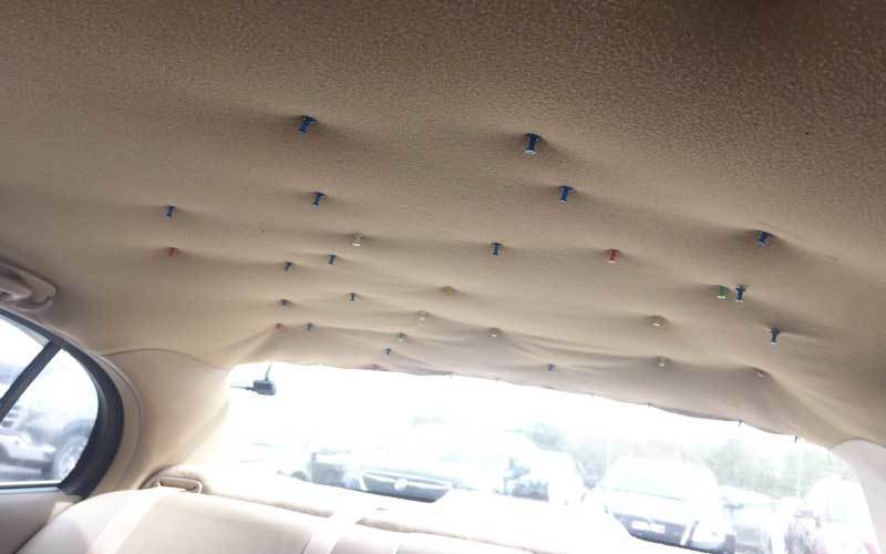 Hold the sagging headliner in place using screw